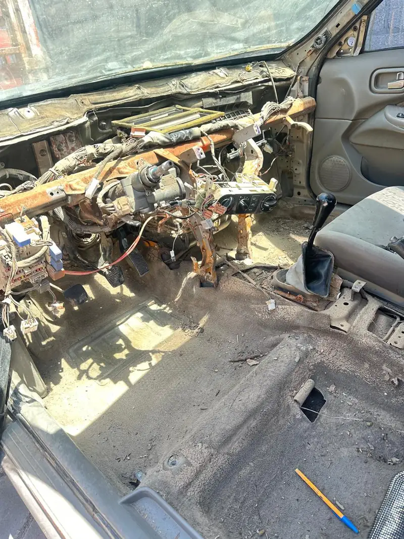 Interior de un Sentra 2007 desarmado para reparar el cableado después de una inundación